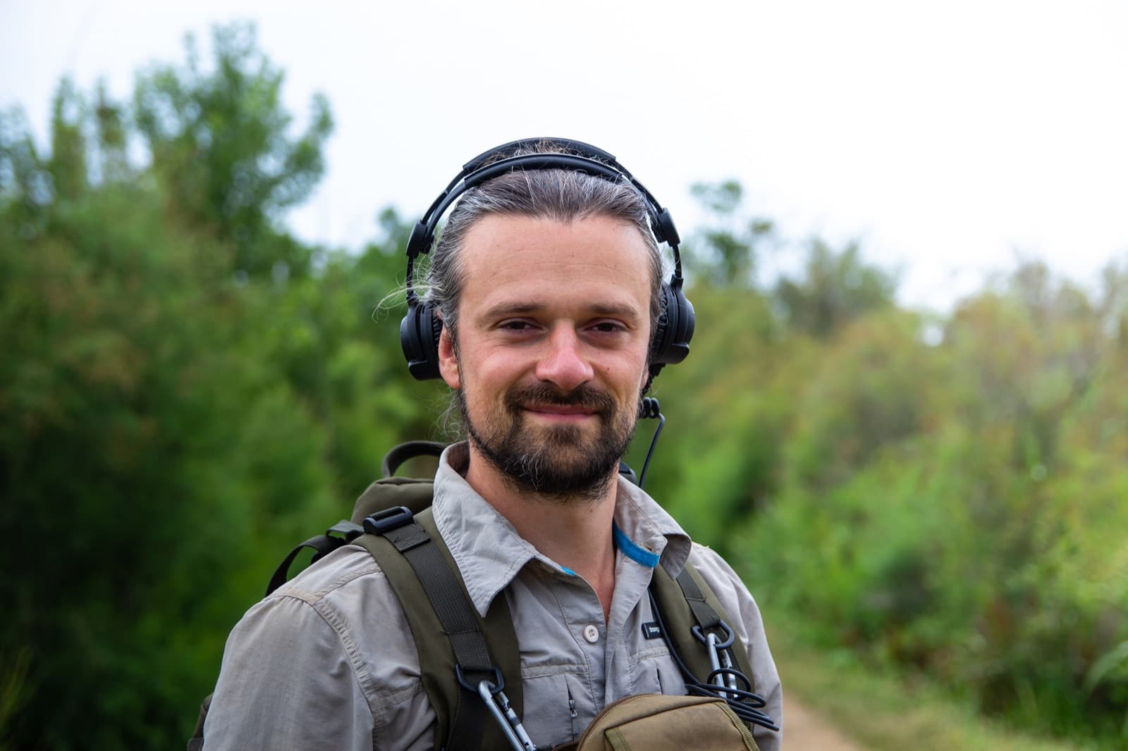Axel Drioli in the field with headphones and recording gear
